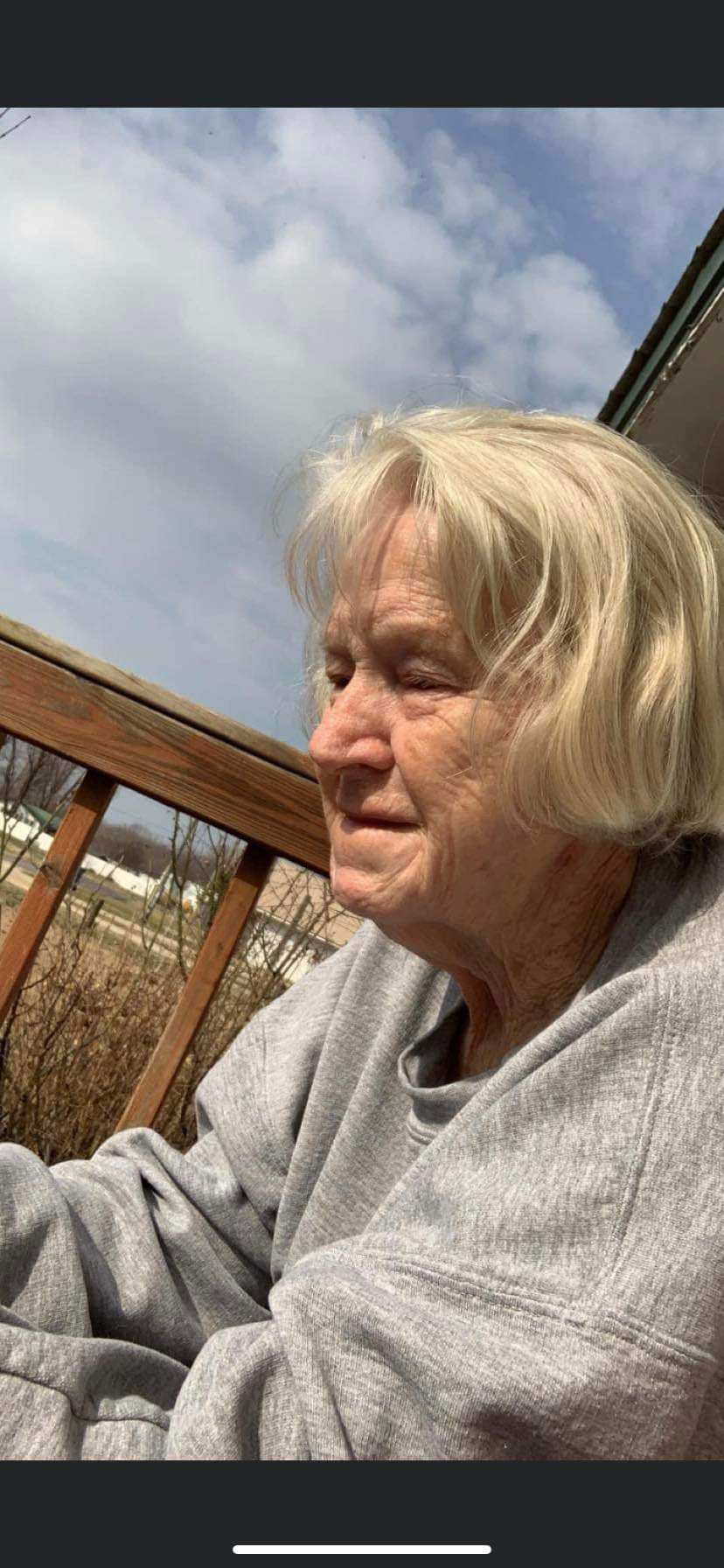 Mother, sitting on the front porch.